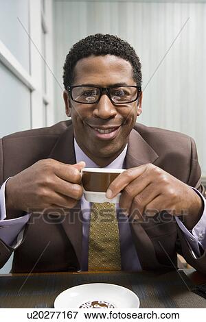 Stock Photo - Businessman drinking coffee on business lunch. Fotosearch
