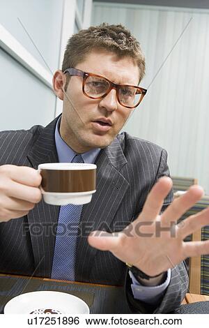 Stock Photograph - Businessman drinking coffee on business lunch. Fotosearch