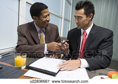 Businessman handing pen over to another businessman View Large Photo Image Stock Photo - Businessman handing pen over to another businessman. Fotosearch