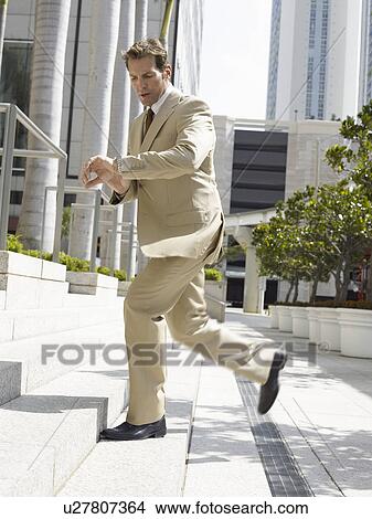 Businessman looking at watch, running to office View Large Photo Image Picture - Businessman looking at watch, running to office. Fotosearch