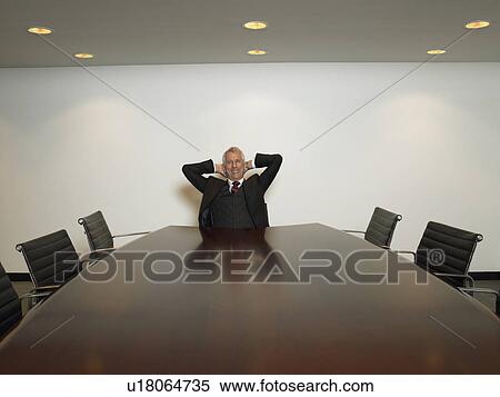 Businessman relaxing in conference room View Large Photo Image Stock Photography - Businessman relaxing in conference room. Fotosearch