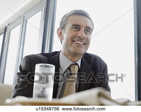 Stock Photograph - Businessman smiling in restaurant. Fotosearch