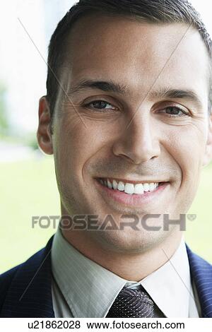 Stock Photo - Businessman smiling outdoors, close-up, portrait. Fotosearch