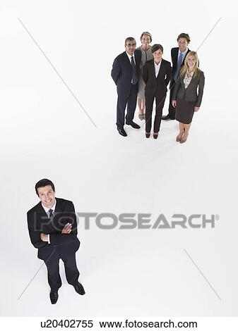 Stock Photography - Businessman standing apart from group. Fotosearch