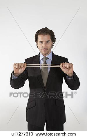 Businessman stretching rubber band, on white background, portrait View Large Photo Image Stock Image - Businessman stretching rubber band, on white background, portrait. Fotosearch