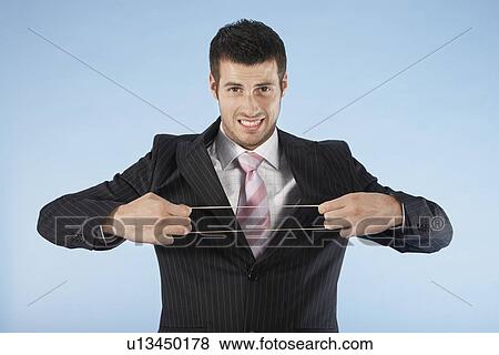Stock Photo - Businessman stretching rubber band, on blue background, portrait. Fotosearch