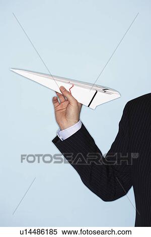 Stock Photography - Businessman throwing paper airplane, close-up of arm and hand. Fotosearch