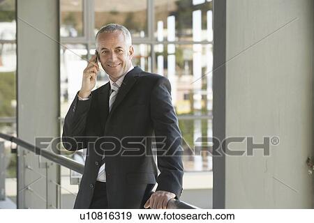 Stock Photo - Businessman Using Cell Phone in Office. Fotosearch