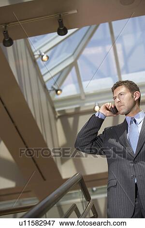 Stock Photo - Businessman Using Cell Phone in office. Fotosearch