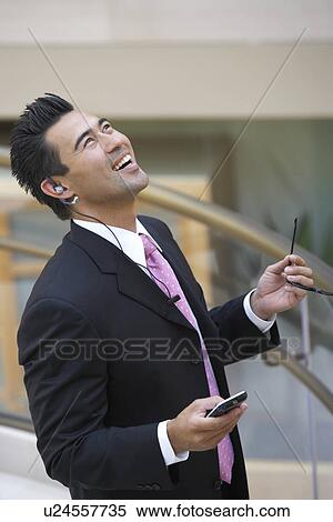 Businessman Using Cell Phone, looking up and laughing, half length View Large Photo Image Stock Photography - Businessman Using Cell Phone, looking up and laughing, half length. Fotosearch