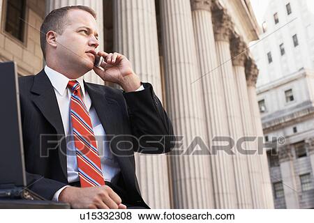 Businessman using mobile phone outside courthouse View Large Photo Image Stock Photo - Businessman using mobile phone outside courthouse. Fotosearch