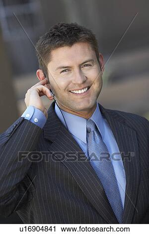 Stock Image - Businessman Using Telephone Headset, smiling, portrait. Fotosearch