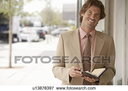 Businessman with diary in street, portrait View Large Photo Image Stock Photo - Businessman with diary in street, portrait. Fotosearch