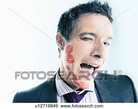 Stock Photo - Businessman with lipstick kiss-marks, winking. Fotosearch