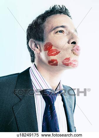Stock Photography - Businessman with lipstick kiss-marks blowing kiss. Fotosearch