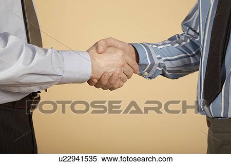 Businessmen shaking hands, mid section View Large Photo Image Stock Photography - Businessmen shaking hands, mid section. Fotosearch