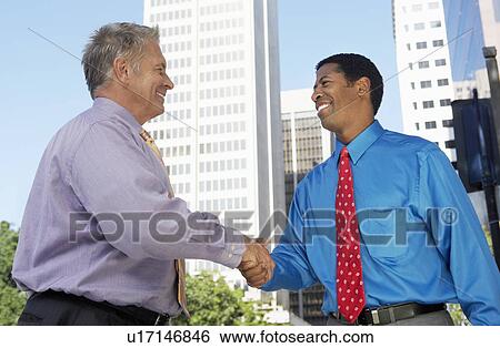Businessmen shaking hands, outdoors View Large Photo Image Stock Photograph - Businessmen shaking hands, outdoors. Fotosearch