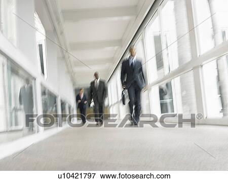 Businessmen walking down corridor, (low angle view) View Large Photo Image Stock Photo - Businessmen walking down corridor, (low angle view). Fotosearch