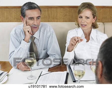 Stock Image - Businesspeople having meeting in restaurant. Fotosearch