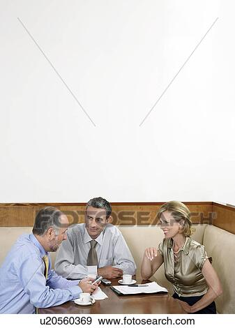 Stock Photo - Businesspeople having meeting in restaurant. Fotosearch