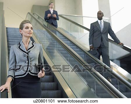 Businesspeople on escalators View Large Photo Image Stock Image - Businesspeople on escalators. Fotosearch