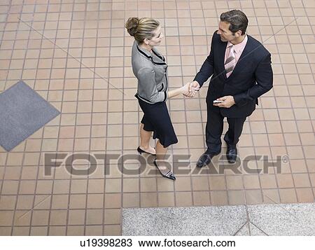 Businesspeople shaking hands indoors, (elevated view) View Large Photo Image Stock Image - Businesspeople shaking hands indoors, (elevated view). Fotosearch