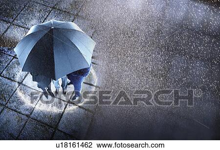 Businesspeople sheltering under umbrella in rain, elevated view View Large Photo Image Stock Image - Businesspeople sheltering under umbrella in rain, elevated view. Fotosearch