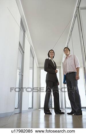 Stock Photography - Businesswoman and Businessman in Corridor. Fotosearch