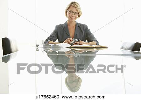 Stock Image - Businesswoman at conference table, portrait. Fotosearch