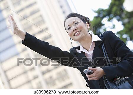 Stock Photo - Businesswoman Hailing a Cab. Fotosearch