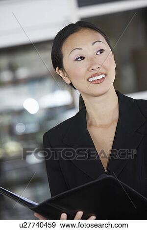 Businesswoman Holding File in office, half length View Large Photo Image Stock Photo - Businesswoman Holding File in office, half length. Fotosearch