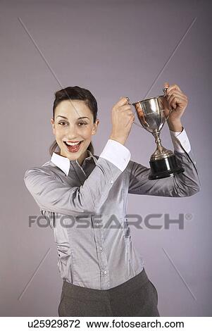Businesswoman holding trophy, portrait View Large Photo Image Stock Image - Businesswoman holding trophy, portrait. Fotosearch