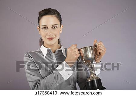 Businesswoman holding trophy, portrait View Large Photo Image Stock Photo - Businesswoman holding trophy, portrait. Fotosearch