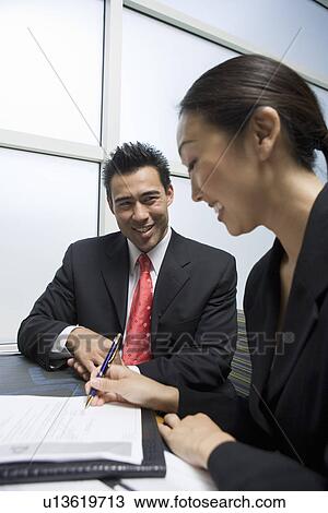 Businesswoman singing agreement with businessman View Large Photo Image Stock Image - Businesswoman singing agreement with businessman. Fotosearch