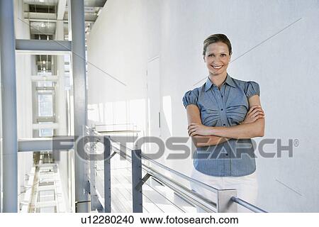 Businesswoman smiling in office building, portrait View Large Photo Image Stock Image - Businesswoman smiling in office building, portrait. Fotosearch