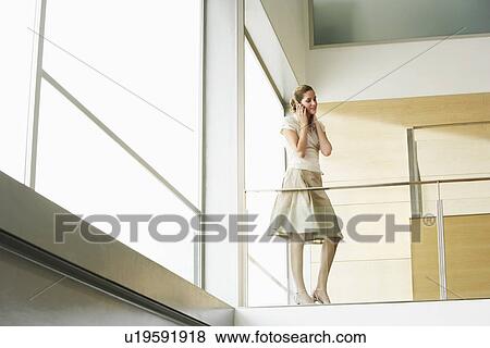 Businesswoman talking on cell phone on Mezzanine View Large Photo Image Stock Photo - Businesswoman talking on cell phone on Mezzanine. Fotosearch