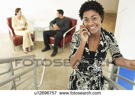 Businesswoman using mobile phone on stairs, portrait View Large Photo Image Stock Photo - Businesswoman using mobile phone on stairs, portrait. Fotosearch