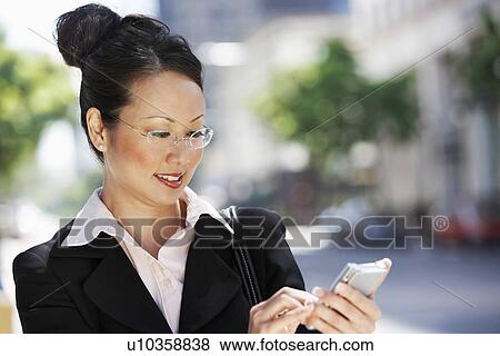 Businesswoman Using Palm pilot, head and shoulders View Large Photo Image Stock Photo - Businesswoman Using Palm pilot, head and shoulders. Fotosearch