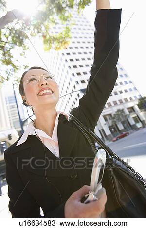 Stock Image - Businesswoman Waving at street. Fotosearch