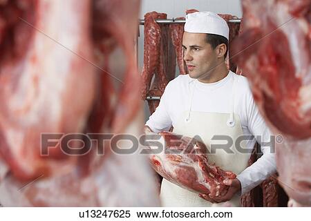 Butcher holding slab of meat, Working in Meat Locker View Large Photo Image Stock Photography - Butcher holding slab of meat, Working in Meat Locker. Fotosearch
