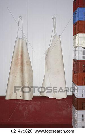 Butcher's Aprons Hanging on Wall next to stack of crates View Large Photo Image Stock Image - Butcher's Aprons Hanging on Wall next to stack of crates. Fotosearch