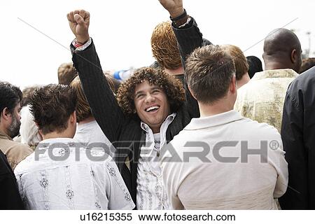 Stock Photography - Cheering man facing the other way to rest of crowd. Fotosearch