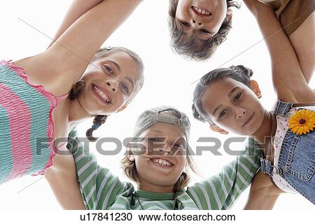 Stock Image - Children arms interlocked, Huddling in a Circle, view from below. Fotosearch