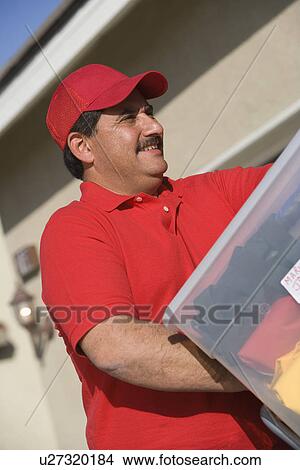 Close-up view of middle-aged delivery man unloading containers View Large Photo Image Picture - Close-up view of middle-aged delivery man unloading containers. Fotosearch