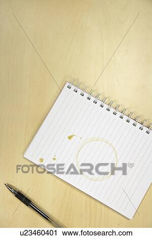 Stock Image - Coffee Ring on Notebook on desk, overhead view. Fotosearch