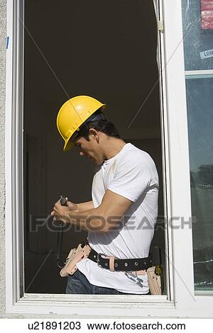 Stock Image - Construction Worker choosing equipment. Fotosearch