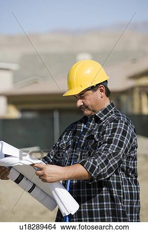 Construction worker examining blueprint View Large Photo Image Picture - Construction worker examining blueprint. Fotosearch