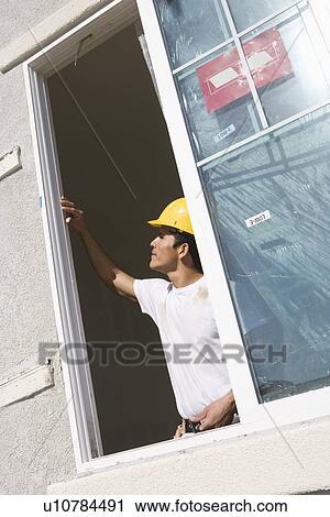 Construction Worker examining window frame View Large Photo Image Stock Image - Construction Worker examining window frame. Fotosearch
