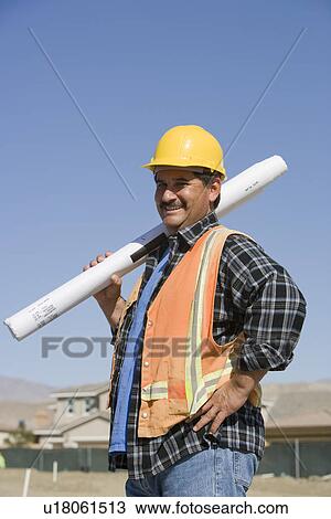 Construction worker holding building plans View Large Photo Image Stock Image - Construction worker holding building plans. Fotosearch