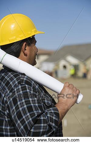 Picture - Construction worker holding rolled up blueprint. Fotosearch